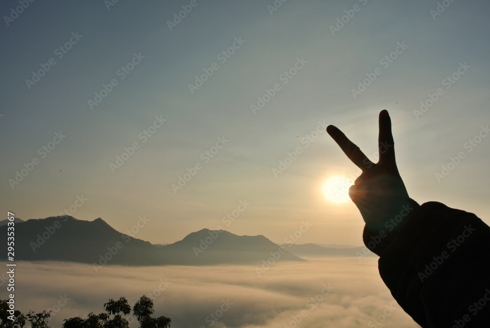 Sunrise on hands on fog and mountain background.