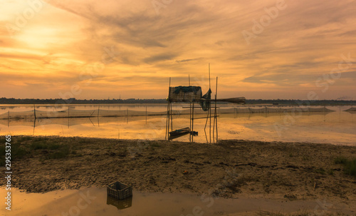 Fishing boats and fishing nets idle beneath cloudy skies on an evening on the Rudrasagar lake in Melaghar in the state of Tripura in Northeast India. photo
