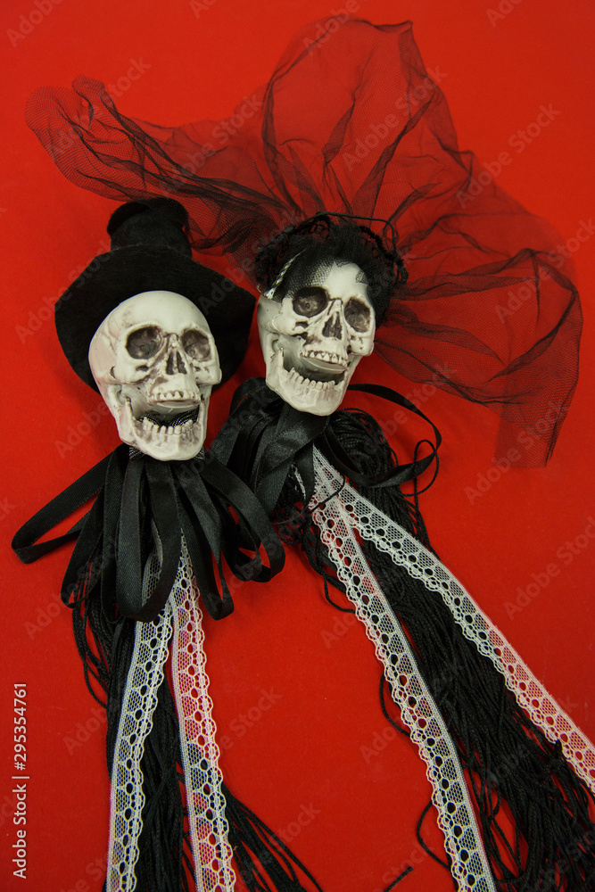 Bride and groom skull wedding dresses symbol of the day of the dead and hallowed, typical american party, with red background