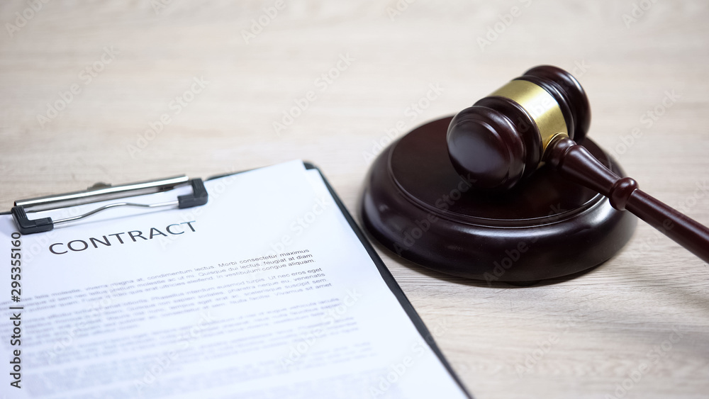 Contract document on table, gavel lying on sound block, legal advice, deal