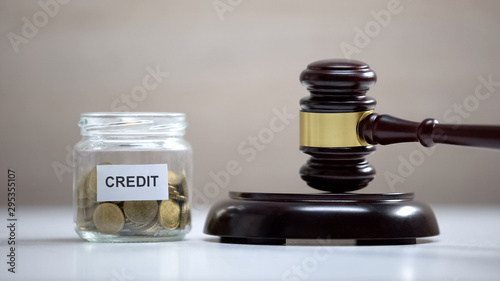 Credit glass jar standing on table, gavel on sound block, finances payment