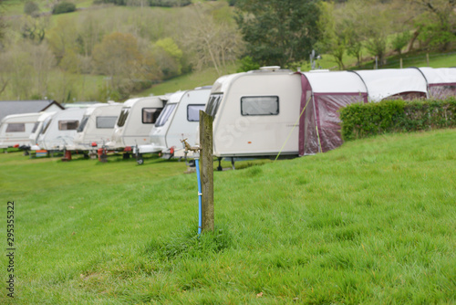 Caravans lined up on their pitches on caravan site with tap in foreground for the caravans to get water from.