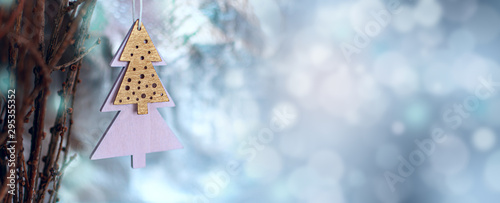 Christmas decoration in minimal style, wooden christmas tree shape. Wide banner, magickal bokeh background, space for text photo