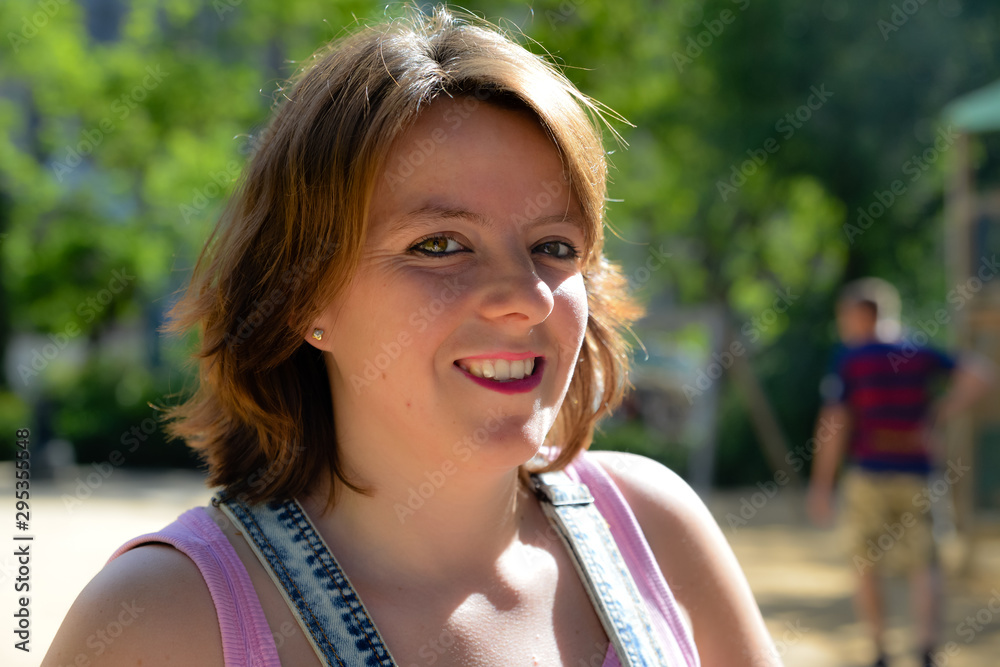 Close up shot of pretty happy smiling young womanon a summers day.