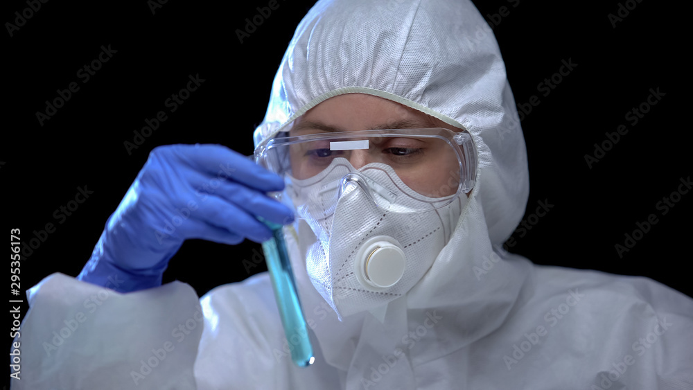 Toxic laboratory worker studying blue fluid in test tube harmful work conditions Toxic laboratory worker studying blue fluid in test tube harmful work conditions