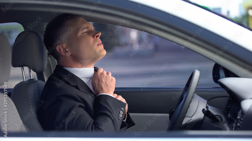 Anxious man adjusting tie in car worried before important meeting, job interview