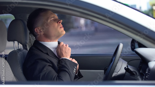 Anxious man adjusting tie in car worried before important meeting, job interview © motortion