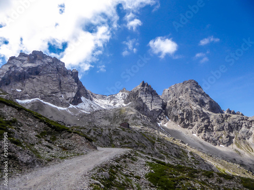 Valley located between sharp and stony mountain range of Lienz Dolomites, Austria. The slopes are barren, with little grass on it. Dangerous mountain climbing. Clear and beautiful day. Natural beauty