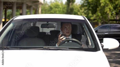 Male driver holding smartphone, distracted driving, road regulations, accident