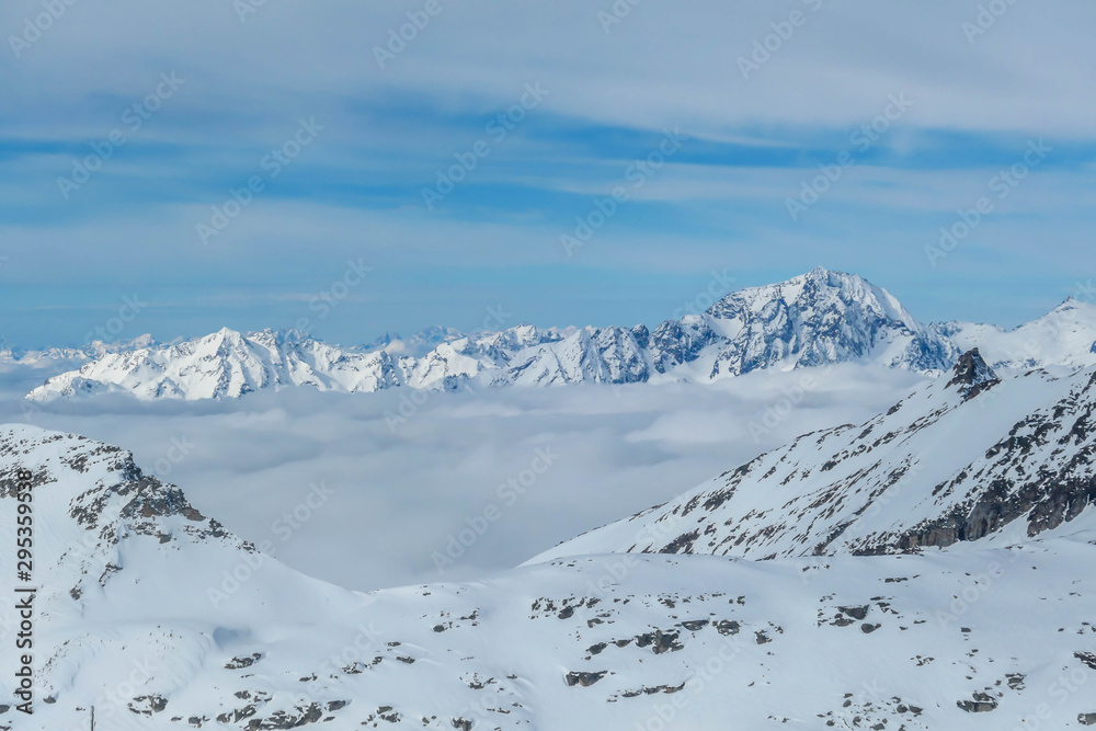 Beautiful and serene landscape of mountains covered with snow in Mölltaler Gletscher, Austria. Thick snow covers the slopes. Clear weather. There is a fog in the valley. Glacier skiing