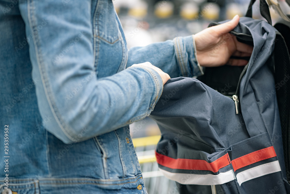 Student girl choosing a new backpack in a store. Student girl choosing a new backpack in a store.