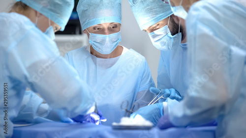 Serious surgeon team performing cardiothoracic surgery, hospital operation photo