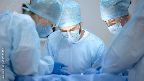 Obraz na płótnie Professional surgeon and assistants performing difficult operation, teamwork
