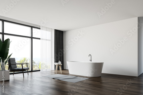 White bathroom corner with armchair and tub