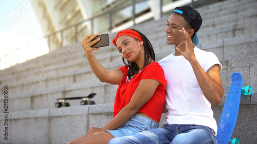 Multi-ethnic teenagers making selfie and having fun sitting on stairs outdoor