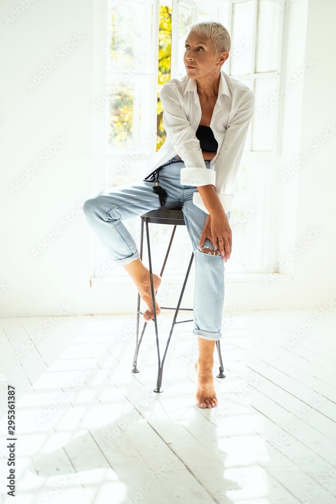Concentrated senior woman shooting in light studio Concentrated senior woman shooting in light studio