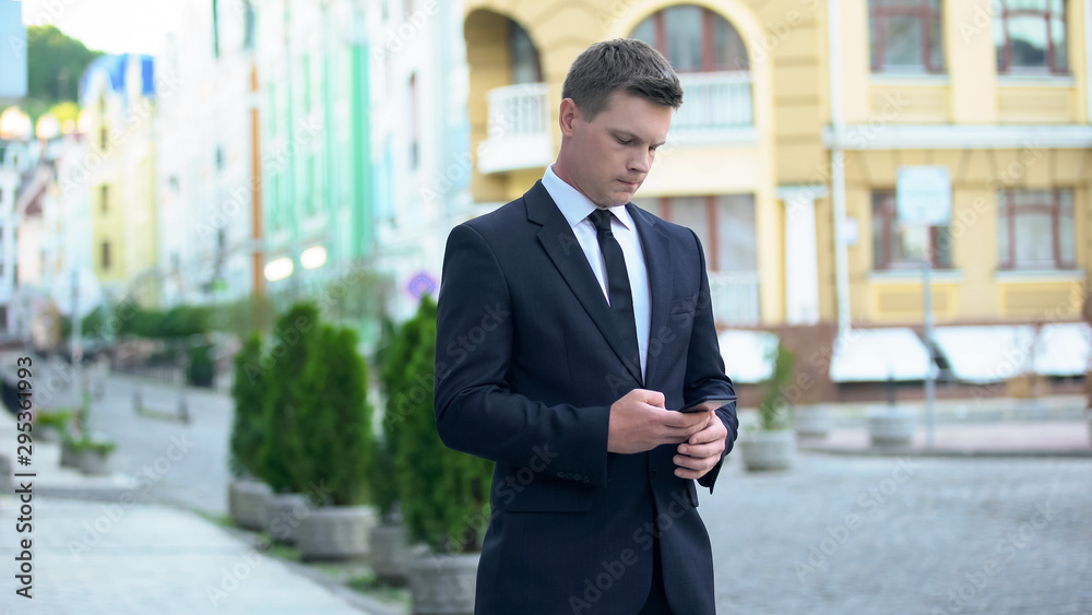 Businessman sending message as walking to work, busy lifestyle, workaholic