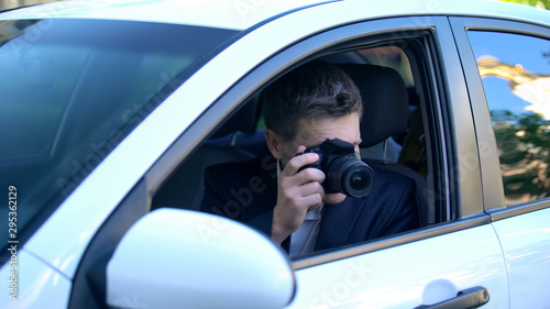 Private detective spying from car, taking photos on camera, investigation © motortion