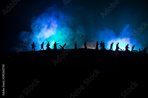 War Concept. Military silhouettes fighting scene on war fog sky background, World War German Tanks Silhouettes Below Cloudy Skyline At night. Attack scene. Armored vehicles and infantry.