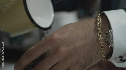 Close up of barber washing a man's hair with water from a cup photo