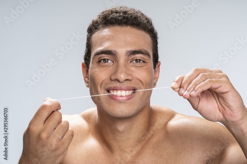 Young man cleaning his teeth in the morning