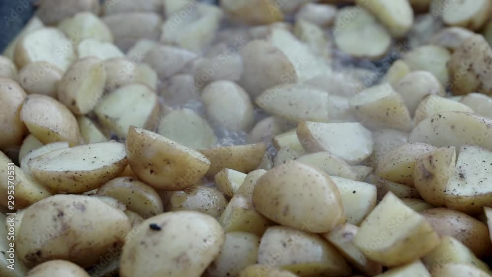 closeup homemade fried potato. Cooking fried potatoes in outdoor conditions on fire. Fire fried potatoes. Simple food. Potatoes in a black pan. closeup homemade fried potato. Cooking fried potatoes in outdoor conditions on fire. Fire fried potatoes. Simple food. Potatoes in a black pan.