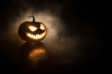 Halloween pumpkin smile and scary eyes for party night. Close up view of scary Halloween pumpkin with eyes glowing inside at black background
