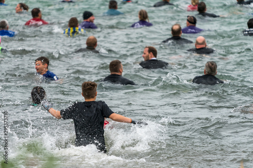 Fototapeta Naklejka Na Ścianę i Meble -  Athlete running into a lake at an obstacle course race