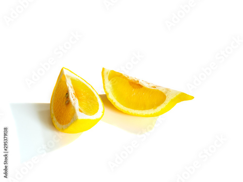 Two yellow ripe slices of the lemon isolated on a white background with shadows.