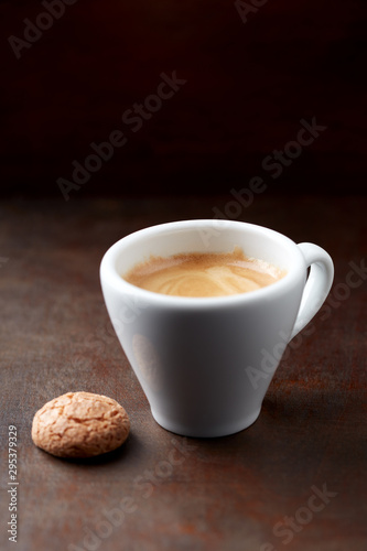 Cup of coffee with amaretti (Italian biscuit) on rustic wooden background. Copy space.