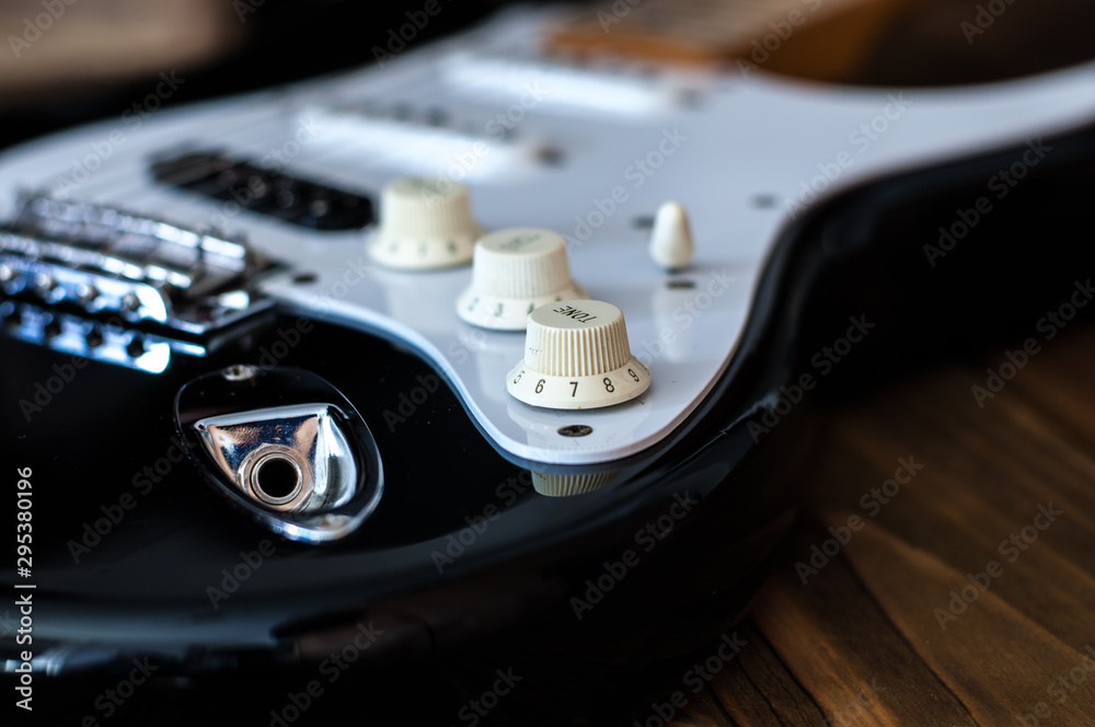 Close up of the electric guitar bridge with focus on the tome knob.