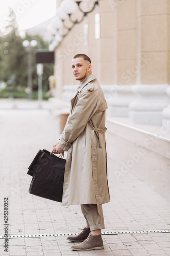 A stylish young man with bags after successful shopping on Black Friday