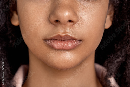 Freestyle. African girl standing isolated on pink serious lips close-up