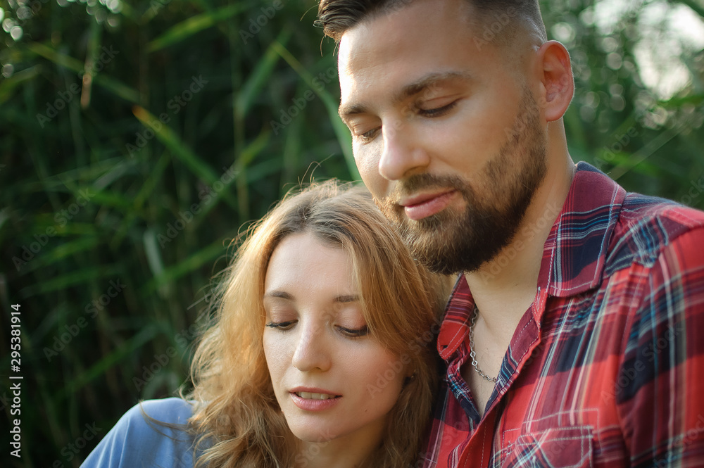 Close up portrait of young couple hugging on green stems background, hipsters concept Close up portrait of young couple hugging on green stems background, hipsters concept