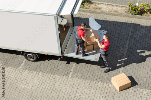 Male Movers Unloading The Cardboard Boxes Form Truck photo