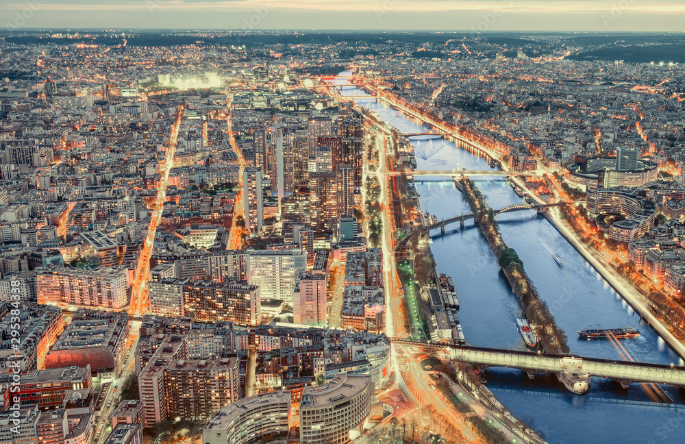 Paris city skyline rooftop view with River Seine at night, France. Evening panorama.