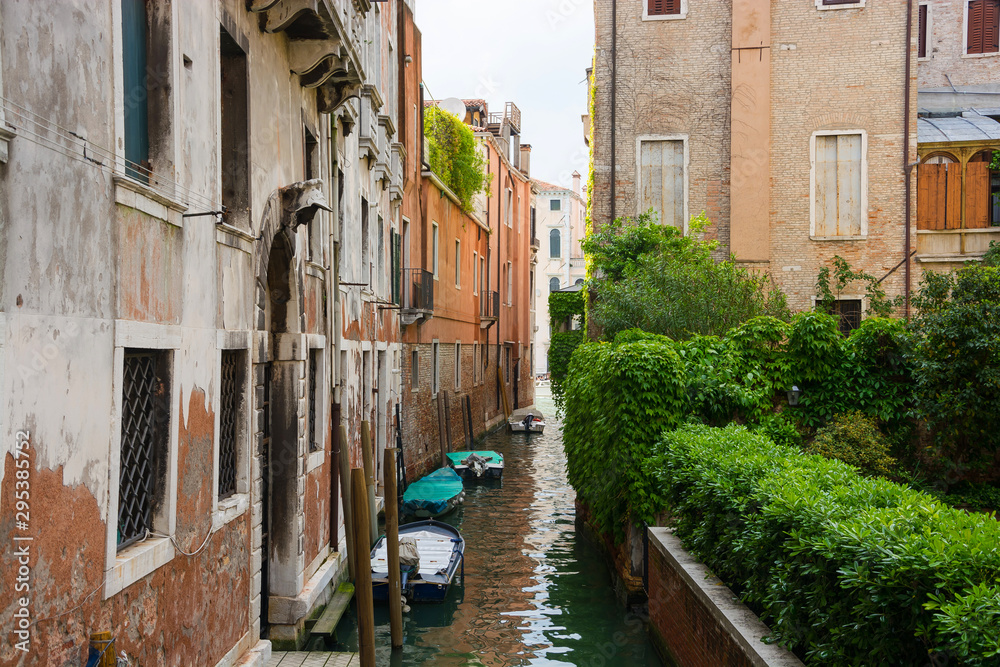 View of the city narrow street and canal in Venice on a sunny day