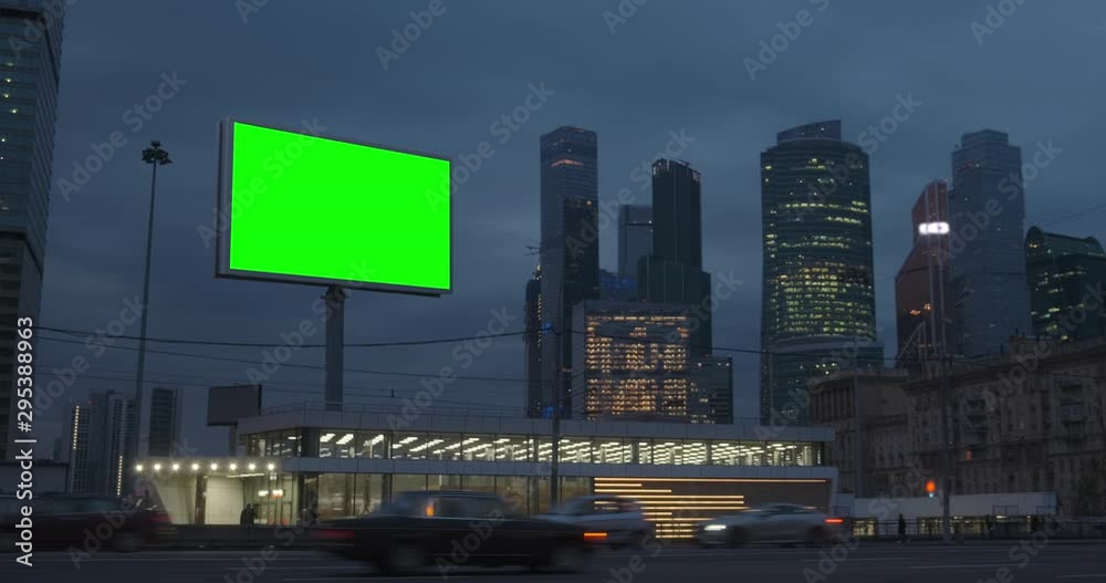 Large billboard with a green screen, a megapolis highway with neon lights, skyscrapers on background, city traffic at night