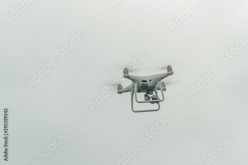 white drone flies against the gray sky close-up. New technologies in aerial photography