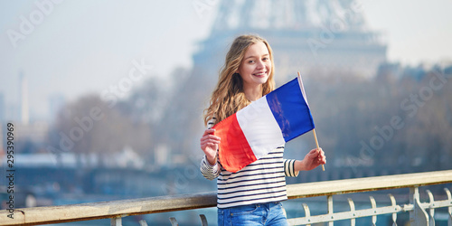 Photography Girl with French national tricolor flag near the Eiffel tower