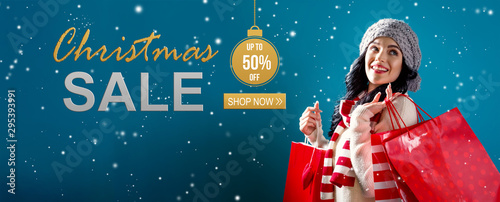 Christmas sale message with young woman holding shopping bags