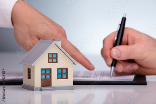 Real Estate Agent Advising Customer For Signing Property Paper