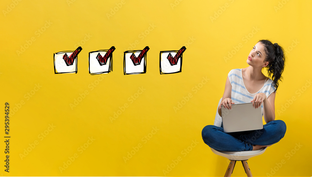Checklist with young woman using a laptop computer - obrazy, fototapety, plakaty 