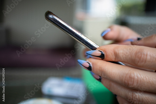 Woman s hands with manicured nails holding smartphone