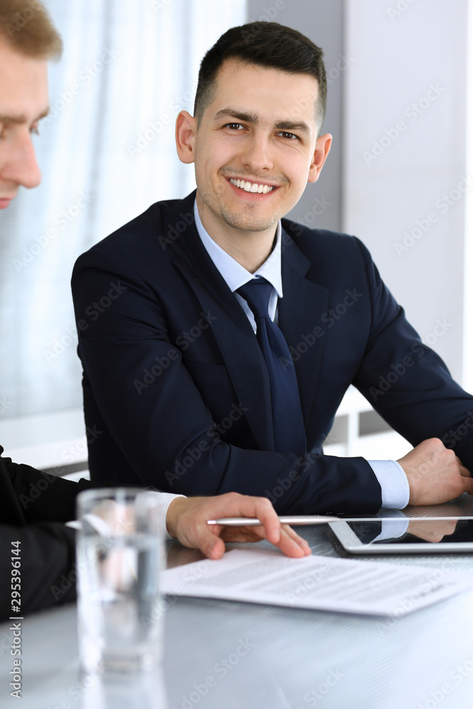 Businessmen or partners working together while using tablet computer at the desk in modern office. Headshot of male entrepreneur or manager with colleague at workplace. Teamwork, partnership and Businessmen or partners working together while using tablet computer at the desk in modern office. Headshot of male entrepreneur or manager with colleague at workplace. Teamwork, partnership and