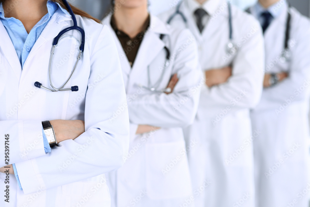 Group of modern doctors standing as a team with arms crossed in hospital office. Physicians ready to examine and help patients. Medical help, insurance in health care, best desease treatment and Group of modern doctors standing as a team with arms crossed in hospital office. Physicians ready to examine and help patients. Medical help, insurance in health care, best desease treatment and