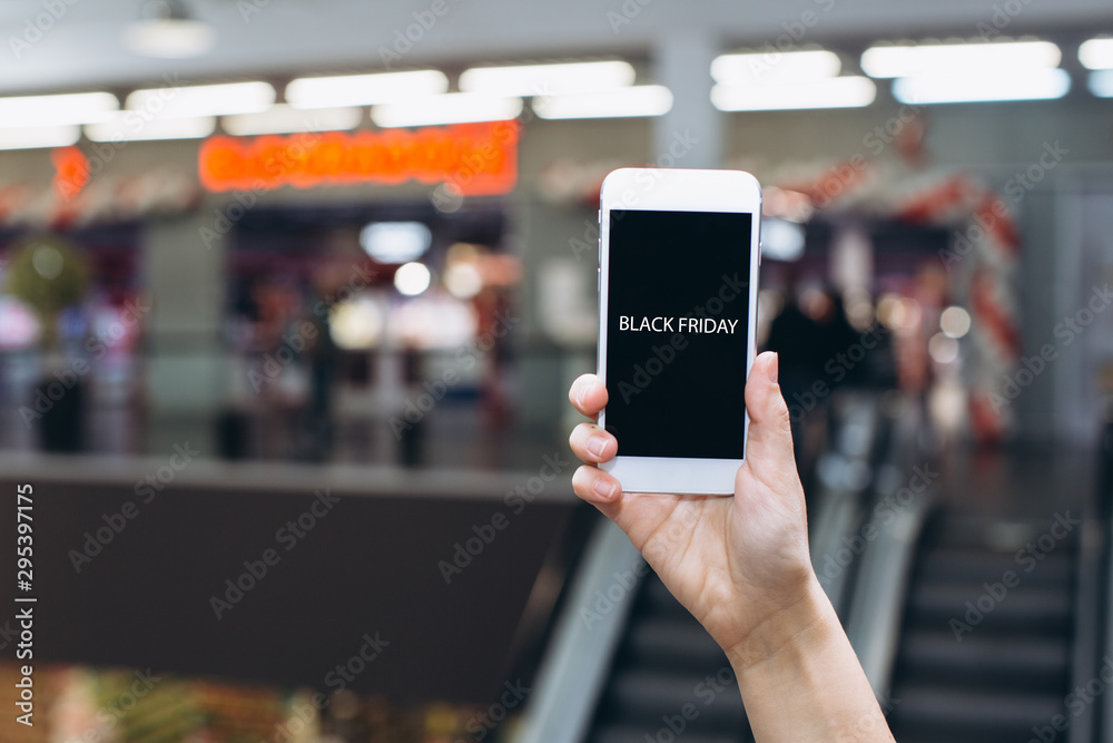 Hand using smartphone for doing business or banking or buying online on blur shopping mall background