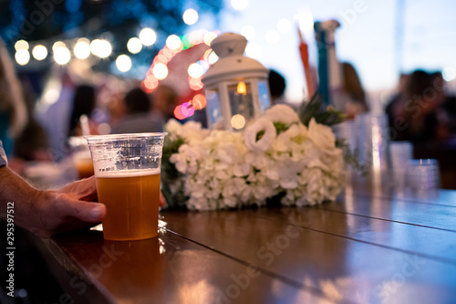 Beer on Bar Table being Held by hand