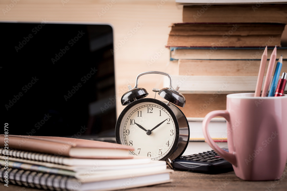 Alarm clock close up on reading table with old stacked book. vintage filter Alarm clock close up on reading table with old stacked book. vintage filter