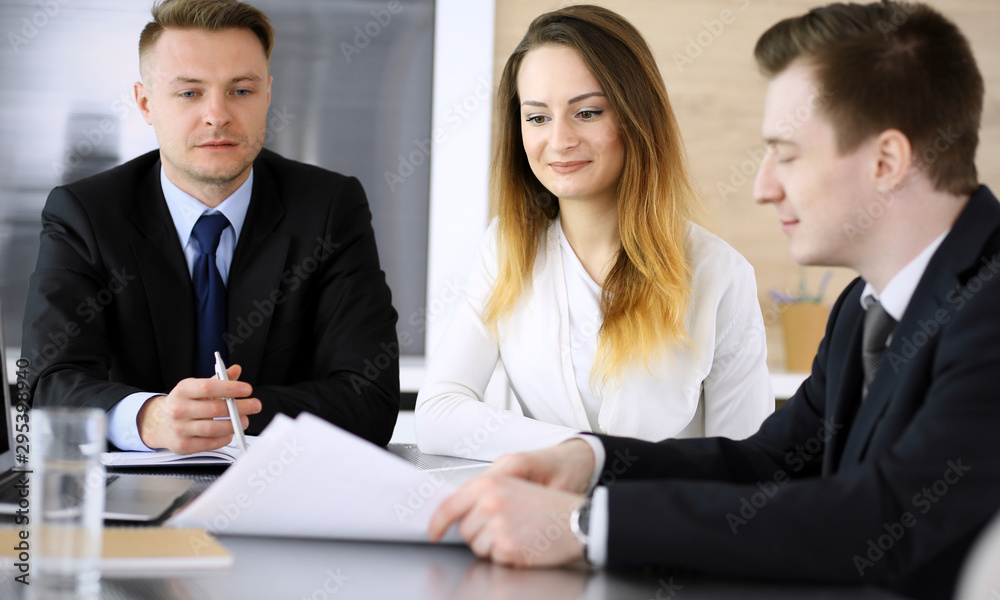 Business people or lawyers discussing questions at meeting in modern office. Unknown businessman and woman with colleague sitting and working at the glass desk. Teamwork and partnership concept Business people or lawyers discussing questions at meeting in modern office. Unknown businessman and woman with colleague sitting and working at the glass desk. Teamwork and partnership concept